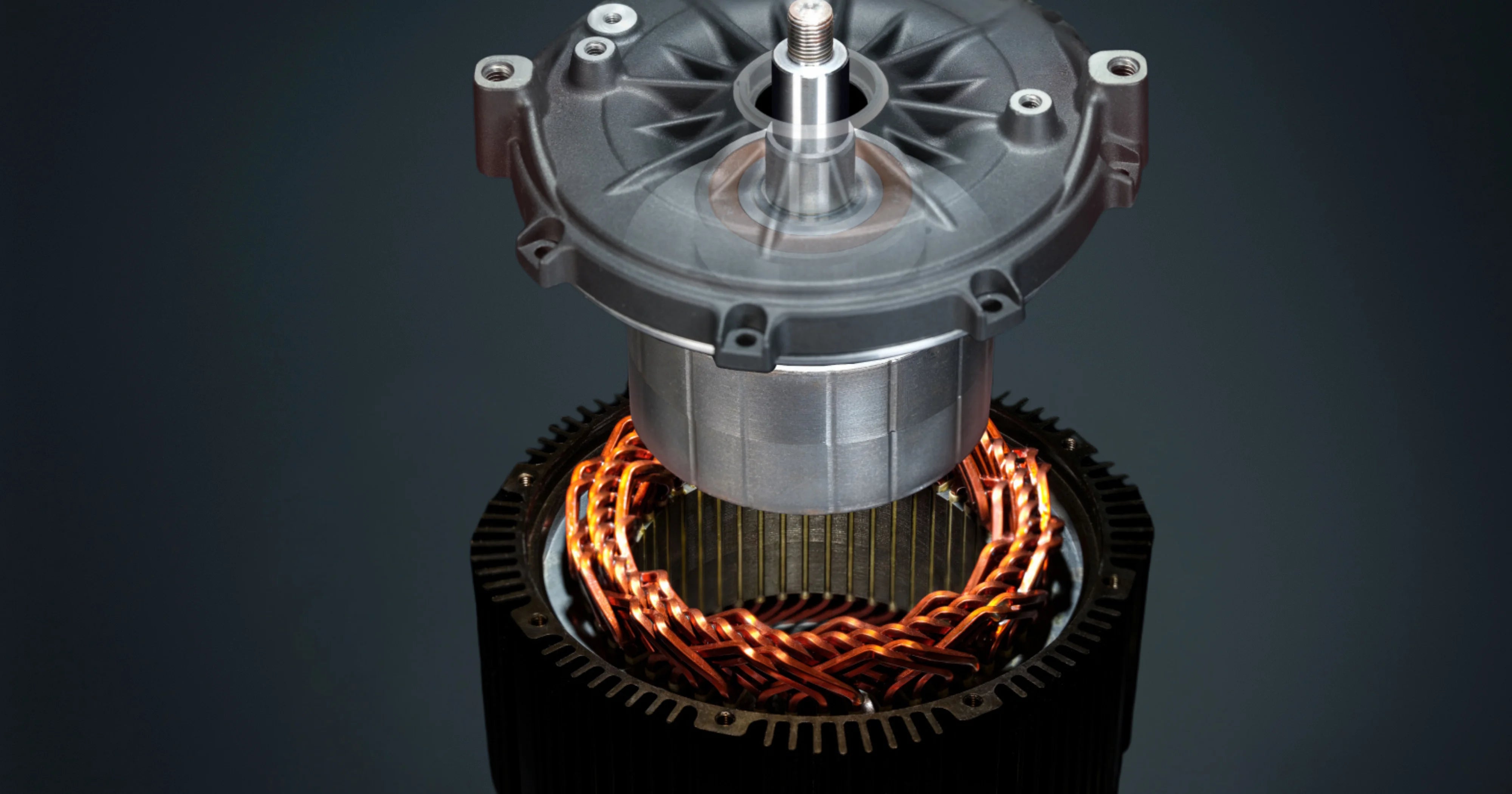 Close-up of an electric motor with metallic and orange components on a dark background