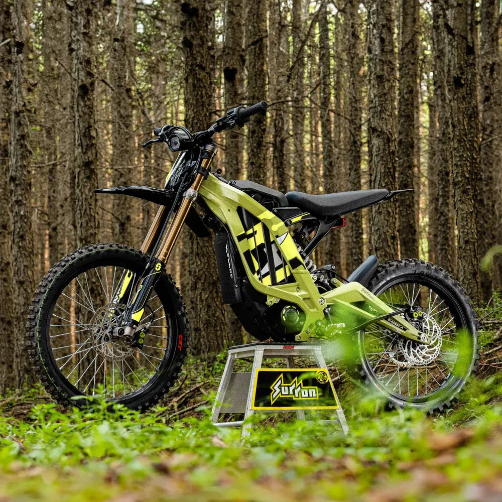 surron 2025 lightbee x  Green off-road bike on a stand in a forest setting