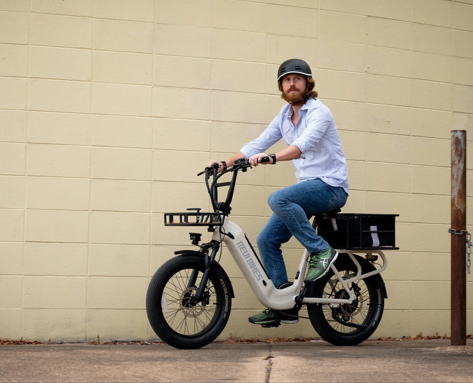 Man sitting on an electric bike against a beige wall