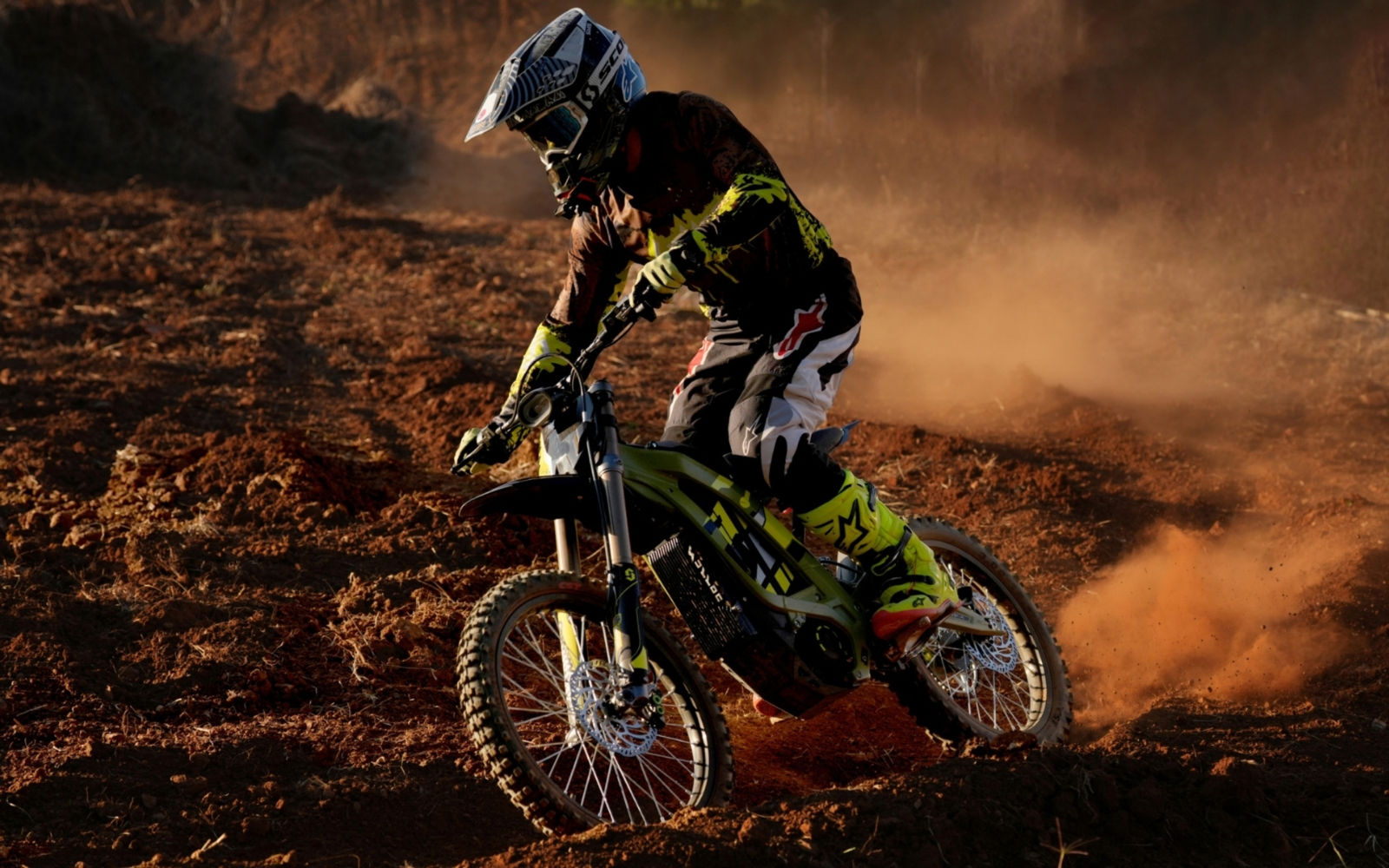 Person riding a surron dirt ebike on a dusty track