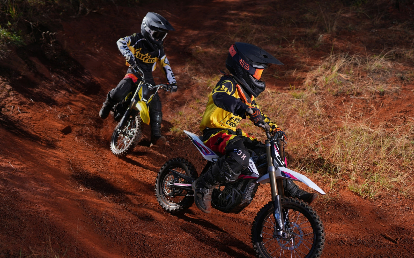 Two hyperbee dirt bikers on a trail with 'KTM' branding.