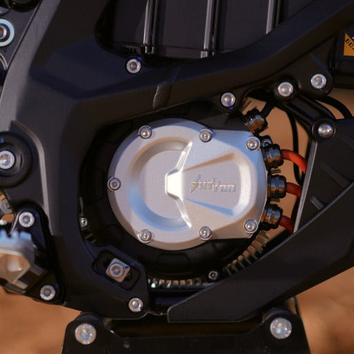 Close-up of a surron ultrabee motorcycle engine and chain on a blurred background