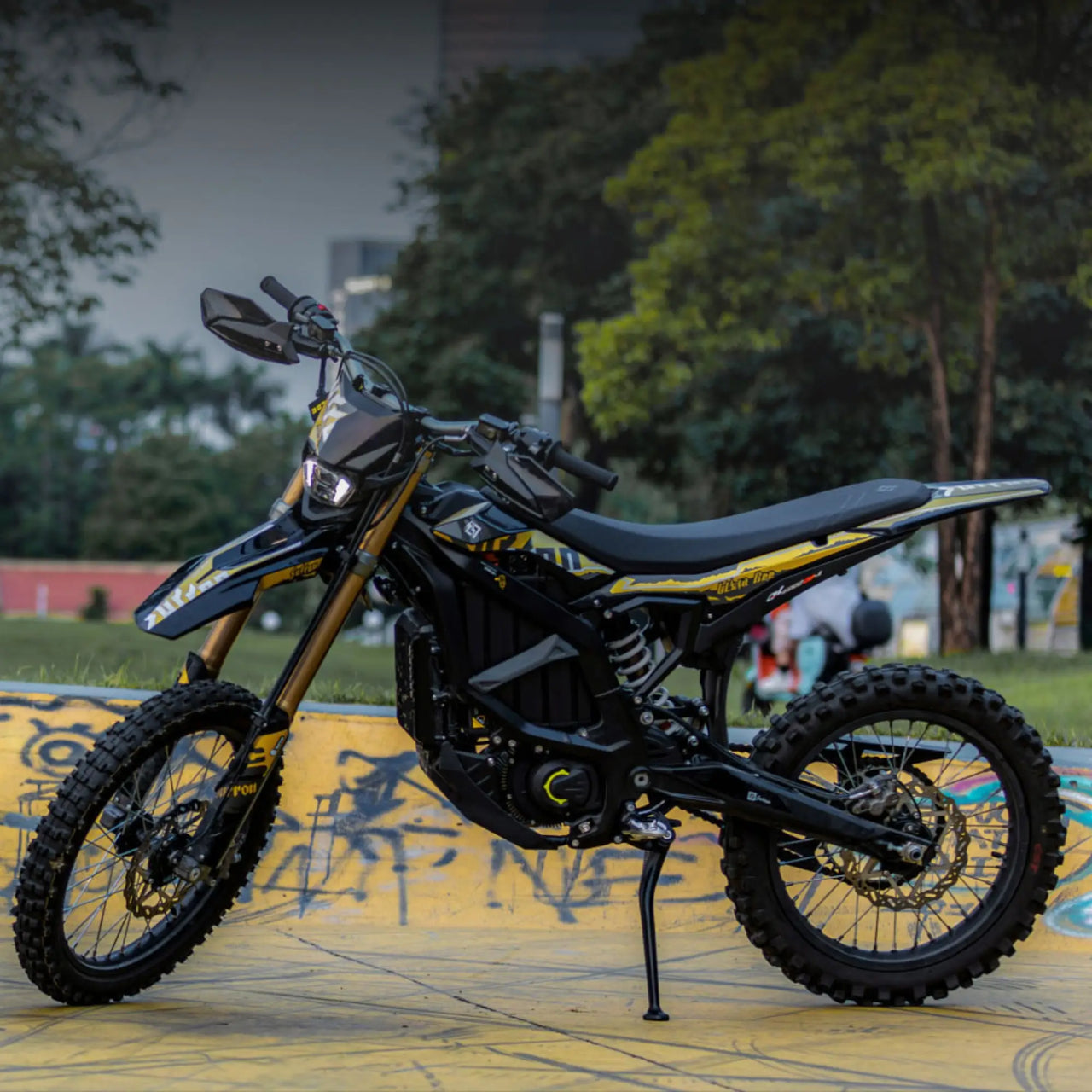 surron ultra bee Motorcycle on a colorful pavement with trees and buildings in the background
